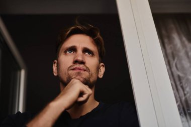 Kapalı portre genç beyaz adam evde üzgün bir ifade, melankoli, üzüntü, depresyon hissediyor