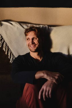 Dairenin arka planında gülümseyen yakışıklı beyaz adamın yakın plan portresi.