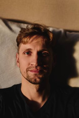 Yakışıklı beyaz adamın yakın plan portresi. Duygusuz yüz ifadesi. Dairenin arka planında ciddi bir yüz.