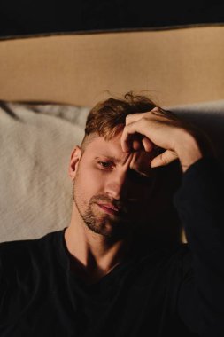 Kapalı portre genç beyaz adam evde üzgün bir ifade, melankoli, üzüntü, depresyon hissediyor