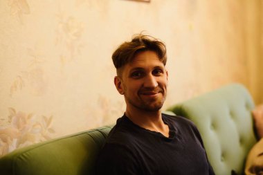 Dairenin arka planında gülümseyen yakışıklı beyaz adamın yakın plan portresi.