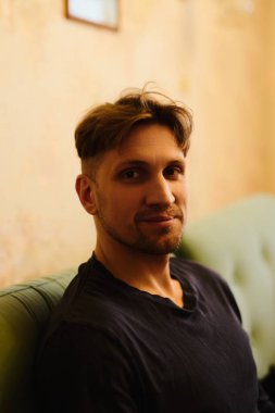 Dairenin arka planında gülümseyen yakışıklı beyaz adamın yakın plan portresi.