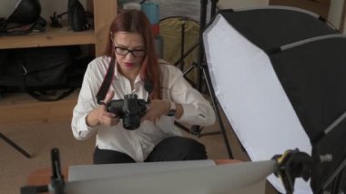 Kadın fotoğrafçı, arka plandaki objelerin fotoğrafını çekiyor. Profesyonel ekipmanlarla birlikte.