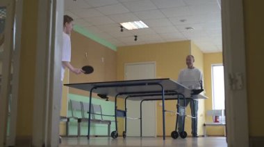 Masa tenisi oynayan iki kişi. Kadın ve erkek masa tenisi kulübünde yarışıyor.