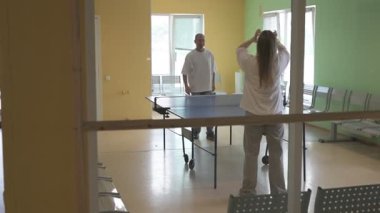 Masa tenisi oynayan iki kişi. Kadın ve erkek masa tenisi kulübünde yarışıyor.