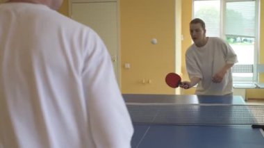Masa tenisi oynayan iki kişi. Kadın ve erkek masa tenisi kulübünde yarışıyor.