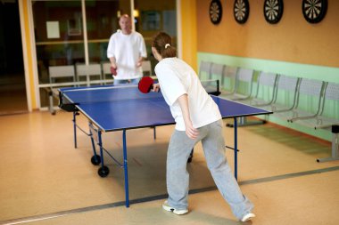 Masa tenisi oynayan iki kişi. Kadın ve erkek masa tenisi kulübünde yarışıyor.