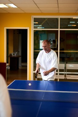 Masa tenisi oynayan iki kişi. Kadın ve erkek masa tenisi kulübünde yarışıyor.