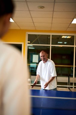 Masa tenisi oynayan iki kişi. Kadın ve erkek masa tenisi kulübünde yarışıyor.