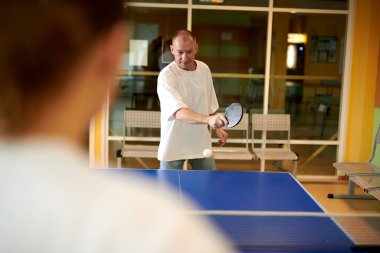 Masa tenisi oynayan iki kişi. Kadın ve erkek masa tenisi kulübünde yarışıyor.