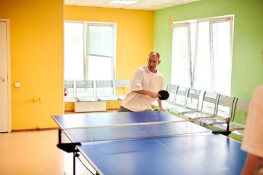 Masa tenisi oynayan iki kişi. Kadın ve erkek masa tenisi kulübünde yarışıyor.