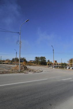 Küçük bir kasabanın sonbahar manzarası. Turuncu yapraklarla kaplı köy evleri ve yollar