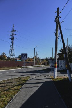Küçük bir kasabanın sonbahar manzarası. Turuncu yapraklarla kaplı köy evleri ve yollar