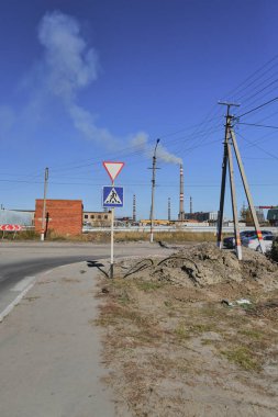 Küçük bir kasabanın sonbahar manzarası. Turuncu yapraklarla kaplı köy evleri ve yollar