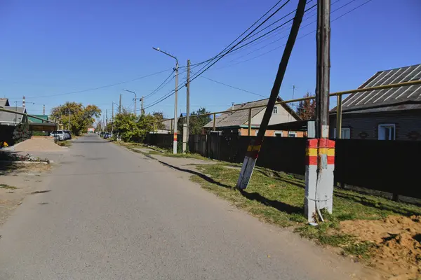 Küçük bir kasabanın sonbahar manzarası. Turuncu yapraklarla kaplı köy evleri ve yollar