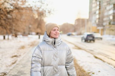 Beyaz kadın portresi. Parkta kış yürüyüşü yaparken ceketi ve şapkası vardı.