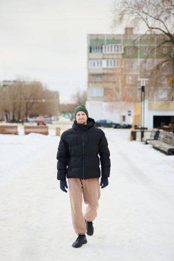 Beyaz bir adamın portresi. Parkta kış yürüyüşü yaparken ceketi ve sıcacık ha.