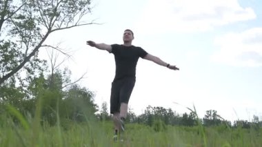 Bir erkek sporcu dışarıda spor alanında antrenman yapıyor. Beyaz erkek sporcu yaz parkında antrenman yapmadan önce ısınma egzersizi yapıyor.
