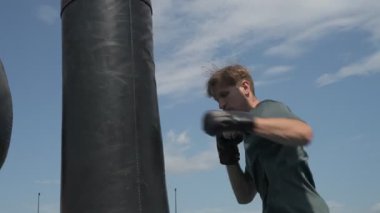 Profesyonel boks antrenmanı, dışarıda kum torbasına vurmak.