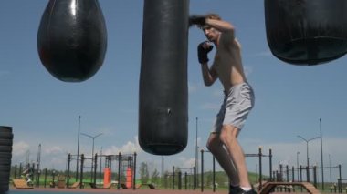 Profesyonel boks antrenmanı, dışarıda kum torbasına vurmak.