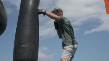 Profesyonel boks antrenmanı, dışarıda kum torbasına vurmak.