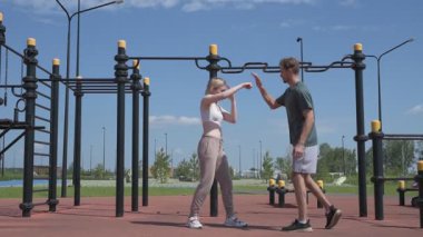 Sporcu erkek ve kız dışarıda boks antrenmanı yapıyorlar.