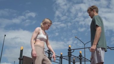 Sporcu erkek ve kız dışarıda boks antrenmanı yapıyorlar.