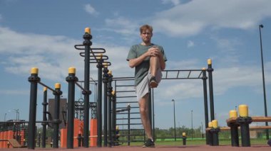 Genç beyaz erkek sporcu spor alanında antrenman yapıyor.