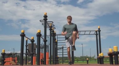 Genç beyaz erkek sporcu spor alanında antrenman yapıyor.