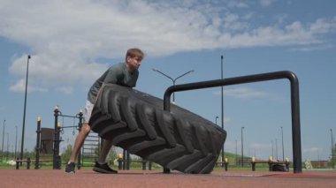 Genç beyaz erkek sporcu spor alanında antrenman yapıyor.