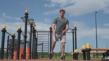 Genç beyaz erkek sporcu spor alanında antrenman yapıyor.