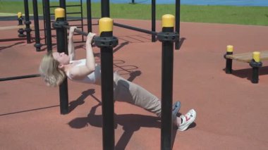 Genç beyaz kadın sporcu spor sahasında antrenman yapıyor.