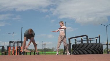 Beyaz erkek ve kadın sporcular spor sahasında antrenman yapıyor.