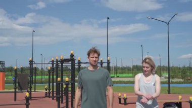 Beyaz erkek ve kadın sporcular spor sahasında antrenman yapıyor.