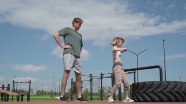 Beyaz erkek ve kadın sporcular spor sahasında antrenman yapıyor.