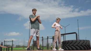 Beyaz erkek ve kadın sporcular spor sahasında antrenman yapıyor.