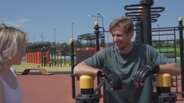 Beyaz erkek ve kadın sporcular spor sahasında antrenman yapıyor.