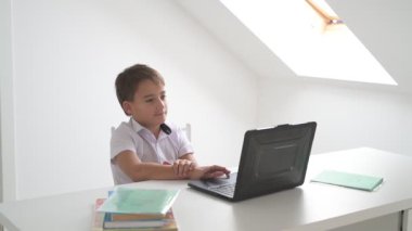 Bilgisayarlı küçük okul çocuğu, internetten uzaktan öğreniyor.