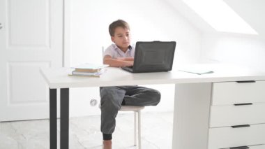 Bilgisayarlı küçük okul çocuğu, internetten uzaktan öğreniyor.