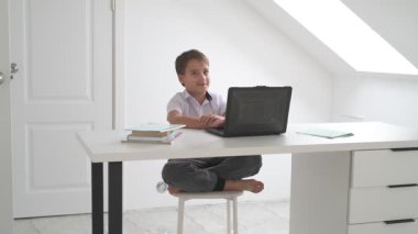 Bilgisayarlı küçük okul çocuğu, internetten uzaktan öğreniyor.