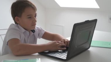 Bilgisayarlı küçük okul çocuğu, internetten uzaktan öğreniyor.