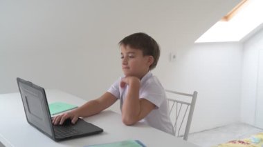 Bilgisayarlı küçük okul çocuğu, internetten uzaktan öğreniyor.