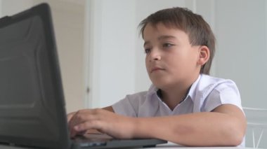 Bilgisayarlı küçük okul çocuğu, internetten uzaktan öğreniyor.