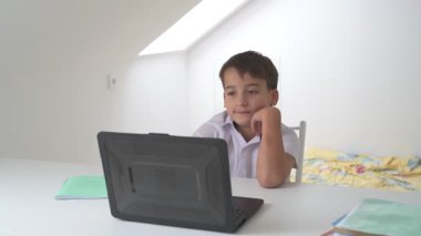 Bilgisayarlı küçük okul çocuğu, internetten uzaktan öğreniyor.