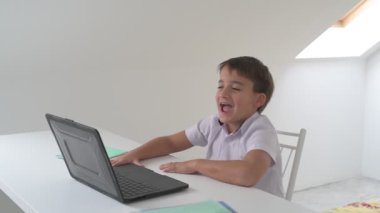 Bilgisayarlı küçük okul çocuğu, internetten uzaktan öğreniyor.