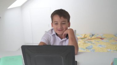 Bilgisayarlı küçük okul çocuğu, internetten uzaktan öğreniyor.