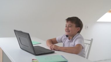 Bilgisayarlı küçük okul çocuğu, internetten uzaktan öğreniyor.