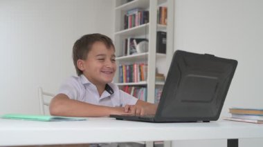 Bilgisayarlı küçük okul çocuğu, internetten uzaktan öğreniyor.