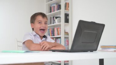 Bilgisayarlı küçük okul çocuğu, internetten uzaktan öğreniyor.