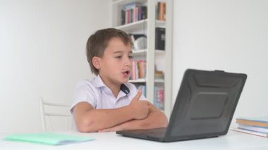 Bilgisayarlı küçük okul çocuğu, internetten uzaktan öğreniyor.